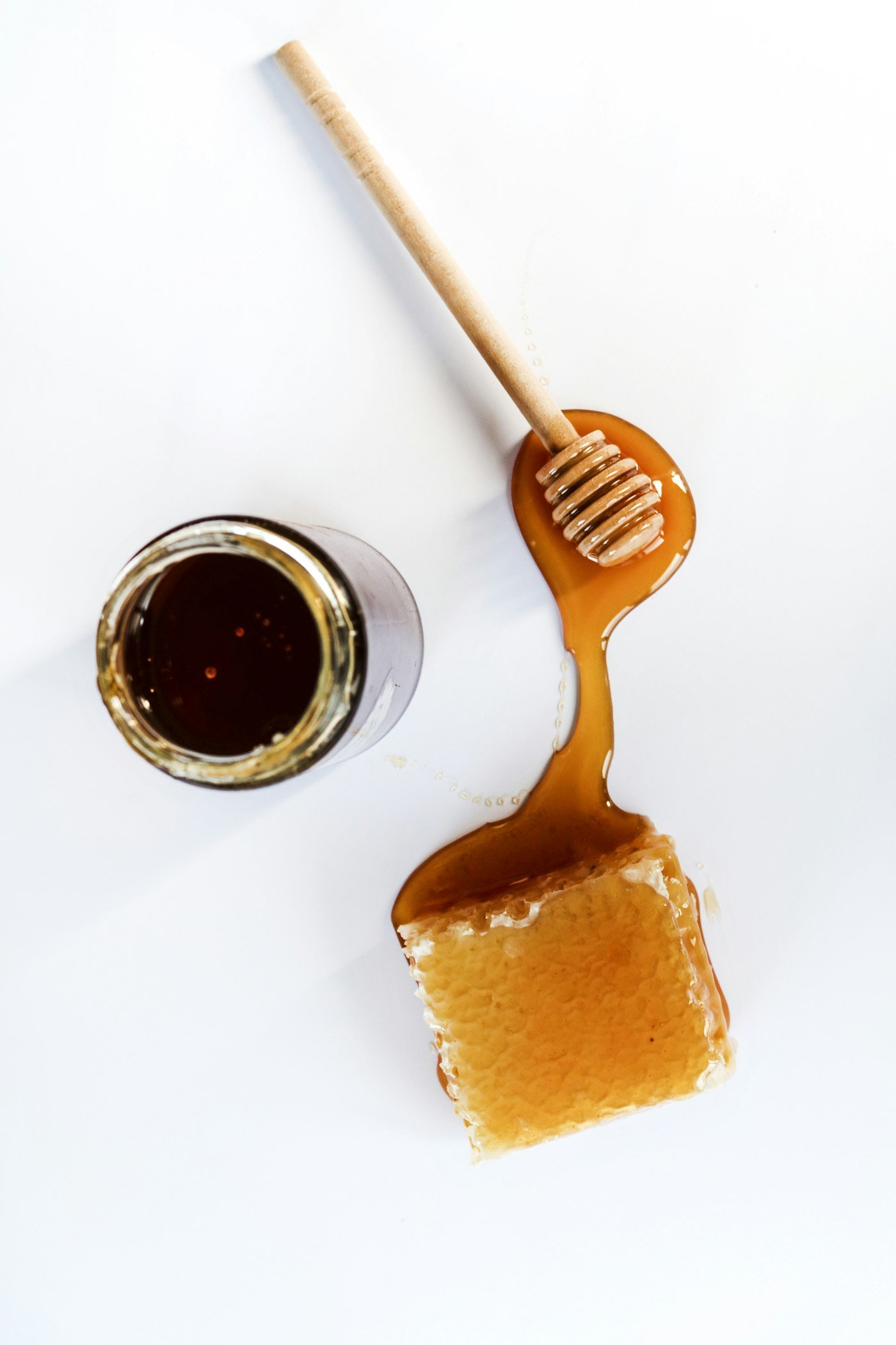 Raw honey with honeycomb and a wooden dipper